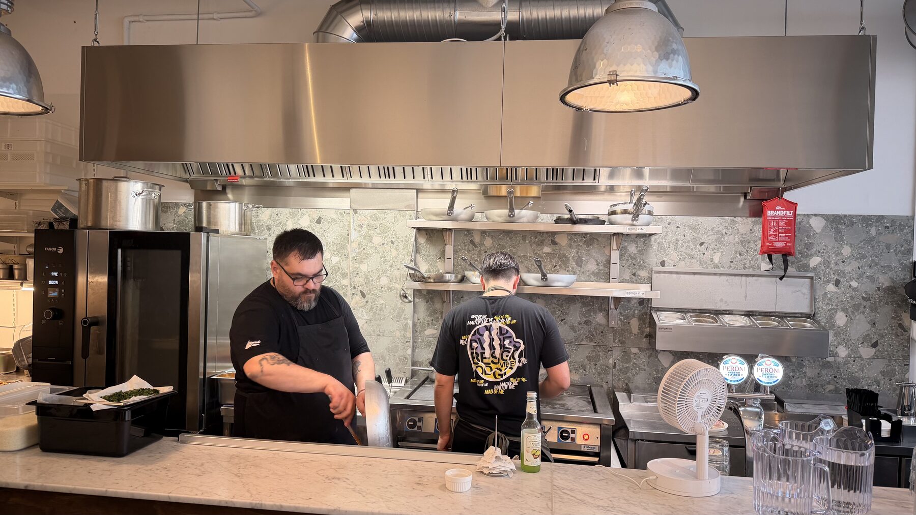 Lorenzo och Bruno lagar mat i det öppna köket bakom bardisken